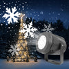 a christmas tree with snowflakes and a spotlight